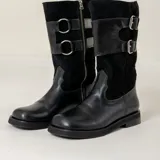 Bota alta de cuero y gamuza negra, con diseño de caña media, doble hebilla lateral y cierre con cremallera. Cuenta con tacón bajo y suela resistente.