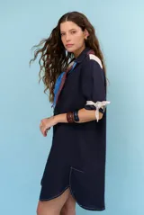 Vestido corto azul marino de lino, con cuello polo, mangas cortas con detalle de lazos y bolsillos frontales.