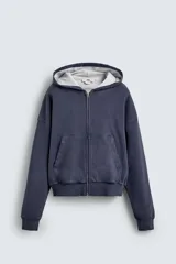 Sudadera de algodón con efecto lavado, color azul oscuro/gris pizarra, de corte 'boxy fit' y cierre frontal de cremallera. El interior de la capucha está forrado en tejido waffle de color gris claro. Posee bolsillos frontales de plastrón.