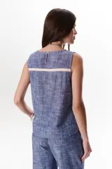 Top sin mangas de corte recto y holgado, confeccionado en tejido de lino con textura jaspeada en tono azul. Presenta cuello redondo y un diseño minimalista ideal para climas cálidos.