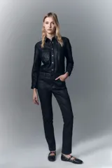 Pantalón de jean con calce skinny y tiro alto, confeccionado en denim negro con un proceso de coating marrón que le otorga una apariencia similar al cuero y un diseño de animal print realizado con láser.