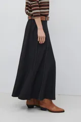 Falda larga de jean color azul oscuro con corte evasé y costuras con pespuntes a contratono. Presenta una cintura elástica para mayor comodidad.