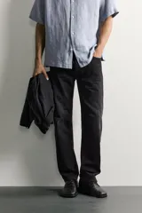 Jeans regular fit confeccionados en denim de algodón celeste con efecto lavado, de cinco bolsillos y cierre frontal con cremallera y botón.