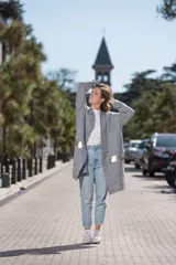 Saco gris de tejido de punto con mangas largas y apliques de cuero dorado en los laterales.