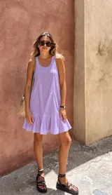 Vestido corto lila de lino con escote redondo, corte suelto y amplio volante en el ruedo.