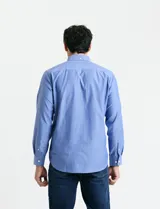 Camisa de manga larga en color azul, con cuello abotonado y bolsillo frontal en el pecho.