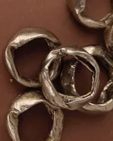 Anillo plateado de bronce, alpaca y plata 925, con forma irregular y textura rústica.