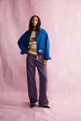 Pantalón de tiro medio de corte recto, color violeta, con cinco bolsillos, trabillas en la cintura y detalle de costuras marcadas en las piernas. Cuenta con presilla lateral de carpintero y cierre frontal con botón y cremallera.