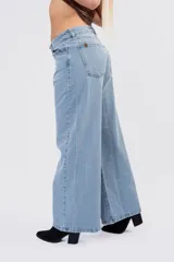 Jean de corte wide leg y tiro bajo, en color celeste clásico con acabado lavado. Presenta diseño de cinco bolsillos, cierre frontal con botón y cremallera, y pernera ancha de caída fluida.