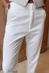 Pantalón sastrero negro de satén, tiro medio y corte recto.