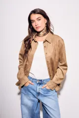 Camisa color marrón de gamuza sintética, de corte recto, con cuello clásico, cierre frontal con botones y mangas largas.