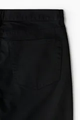 Pantalón slim fit negro de sarga de algodón, de corte ajustado, con cinco bolsillos y cierre frontal con botón y cremallera.