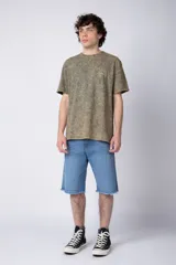 Remera de algodón con efecto de lavado desgastado tipo snow wash, de corte semi-oversize, cuello redondo y manga corta. Presenta un pequeño estampado gráfico circular en el pecho.