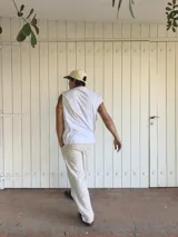 Pantalón de lino beige y crudo a rayas, de corte ancho y relajado.