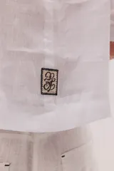 Blusa de lino color marrón con cuello mao, escote en V y mangas largas.
