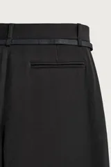 Pantalón de corte balloon fit confeccionado en tejido con viscosa. Presenta cintura ajustable con cinturón integrado, pliegues frontales, bolsillos laterales y bolsillos traseros de doble vivo. Cierre frontal con cremallera y botón.