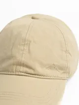 Gorro con visera color beige, con logo bordado de una montaña en el frente.