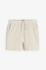 Short de felpa liviana color beige, con cintura elástica y cordón ajustable. Incluye bolsillos al bies y un bolsillo abierto en la parte trasera. Corte estándar.