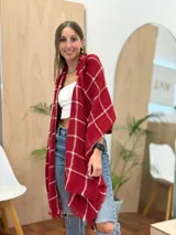 Bufanda rectangular color rojo con estampado de cuadros blancos y terminación con flecos.
