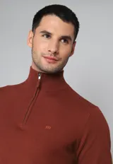 Sweater color ladrillo de tejido de punto, con cuello alto y cierre metálico a la mitad del pecho.