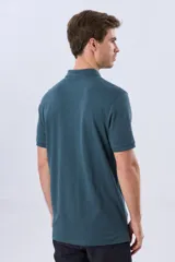 Remera polo de piqué de algodón color azul, de manga corta, con cuello camisero, cierre frontal de dos botones y pequeño logo bordado en el pecho.
