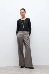 Pantalón sastrero de corte recto y tiro alto, confeccionado en tela con textura melange en tono beige. Presenta cierre frontal con botón y bolsillos laterales.