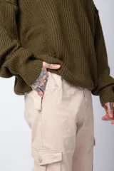 Pantalón cargo color beige, con bolsillos laterales tipo cargo con solapa y cierre de botón, corte recto y ajuste cómodo.