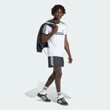 Remera Adidas modelo 3S Ringer de color blanco, con cuello redondo y ribetes en las mangas de color negro. Presenta el logotipo y el texto de la marca estampados en el pecho en color negro, junto con las clásicas tres tiras en los hombros y mangas.