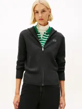 Cardigan de punto gris oscuro con cierre frontal de cremallera, cuello alto y mangas largas. Presenta puños y dobladillo acanalados, y el logo bordado de Tommy Hilfiger en el pecho.