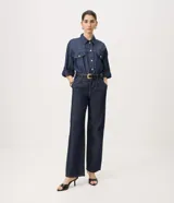 Pantalón de jean azul oscuro de corte recto y tiro alto, inspirado en la sastrería. Presenta pinzas delanteras, bolsillos funcionales y pretina con pasacintos.