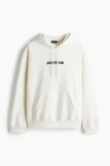 Canguro de algodón con capucha y cordones ajustables, bolsillo frontal tipo canguro, hombros caídos y puños acanalados. Presenta un estampado frontal con el logo de Ford GT.