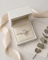 Anillo de plata con diseño triangular y piedra de la luna natural ovalada en el centro.
