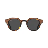 Lentes de sol con montura redonda de eco acetato en patrón carey y detalles de madera en la parte superior. Las lentes son de color gris oscuro.