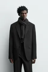 Blazer de corte regular confeccionado en tejido de lana italiana. Presenta cuello con solapas de muesca, cierre frontal de un botón, bolsillos laterales con solapa y bolsillo de vivo en el pecho. Incluye aberturas en la espalda y forro interior.
