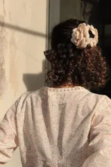 Camisa estampada con flores pequeñas, escote en V con detalle de puntilla, mangas largas abullonadas y cierre frontal con botones.