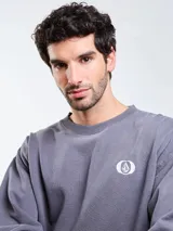 Buzo de cuello redondo Volcom de color gris oscuro, con diseño liso y pequeño logo estampado en el pecho. Cuenta con mangas largas y puños elastizados.
