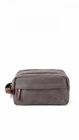 Neceser de tela canvas color gris, con doble compartimento con cierre, bolsillo frontal y asa lateral de cuero sintético.