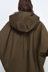 Trench corto de corte recto con capucha y cuello desmontable efecto pelo. Presenta cierre frontal con botones, bolsillos laterales y mangas largas con trabillas en los puños.