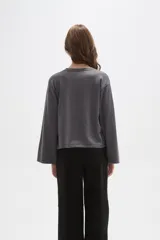 Remera de manga larga confeccionada en viscosa, con cuello redondo a la base y diseño holgado.