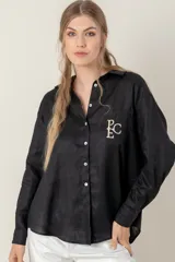 Camisa de lino color gris claro con bordado de monograma PEC en el bolsillo.