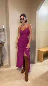 Vestido midi color uva con escote corazón, tirantes finos y aberturas laterales en la cintura. Presenta un diseño con frunces frontales y una falda con tajo lateral.