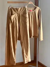 Pantalón tipo palazzo color camel de jersey de algodón, con tiro medio, faja ancha en la cintura y bolsillos delanteros aplicados.
