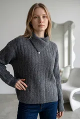 Sweater de punto gris con textura acanalada, cuello alto con solapa cruzada y detalle de botón metálico.