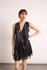 Vestido corto de corte holgado con diseño de doble capa, presentando una capa superior de red y una capa inferior lisa. Posee escote en V profundo, sin mangas y un lazo ajustable en la espalda.