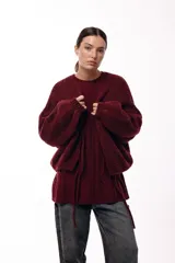 Sweater de punto con textura en color bordó, de silueta relajada, cuello redondo y mangas largas con puños ajustados.