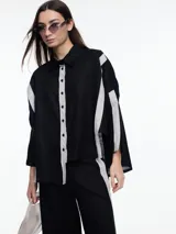 Camisa de lino roja con silueta amplia y mangas 3/4. Diseño con tiras de color rosa en contraste en la cartera, mangas y cuerpo. Tiene tajos laterales y ruedo irregular en el frente.