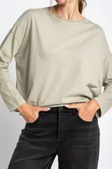 Remera color verde oliva de algodón peinado, corte oversize y mangas largas.