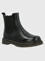 Bota tipo Chelsea de cuero negro con paneles laterales elásticos, suela de goma gruesa con costuras amarillas visibles y tirador trasero.