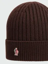 Gorro de lana tejido a punto acanalado, color marrón oscuro, con el logo de Moncler bordado en la parte frontal.