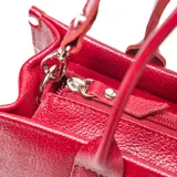 Cartera mediana de cuero con textura granulada, diseño rectangular y logo XL grabado en el frente. Cuenta con doble asa superior y correa larga ajustable y extraíble con hebilla metálica.